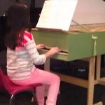 Student Mia playing on a harpsichord